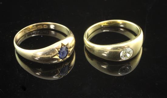 An early 20th century 18ct gold and gypsy set solitaire diamond ring and a similar solitaire sapphire ring, sizes O & Q.